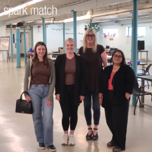 Four women standing in a warehouse loft space